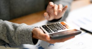 Close up woman hand using calculator