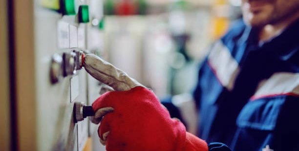 Close up of energy plant worker pressing button on dashboard
