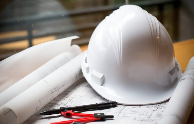 construction concept image helmet rolled blueprints on wooden bo